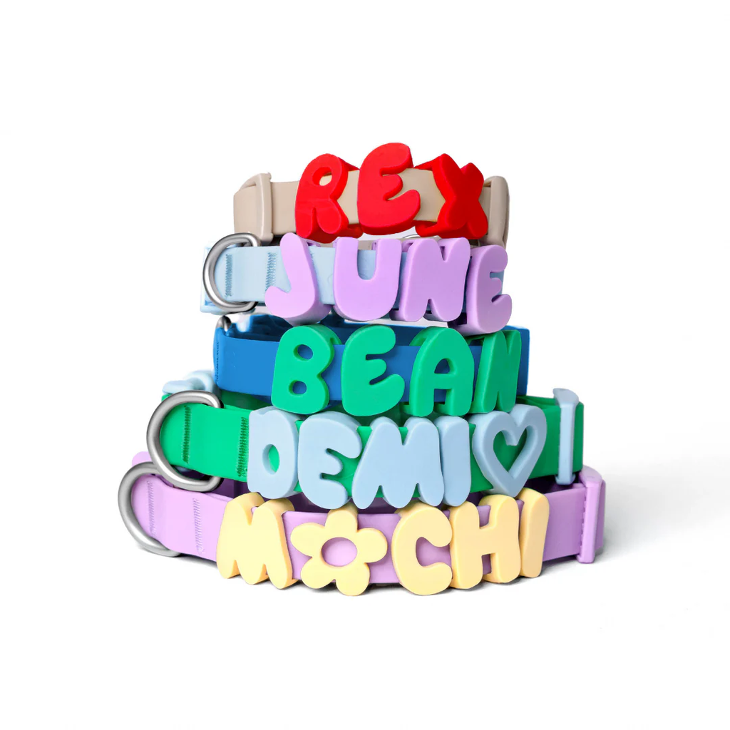 Stack of personalized waterproof collars with name charms